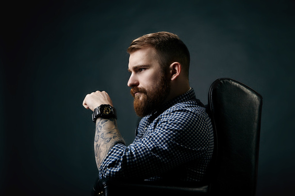 Thoughtful red bearded man studio portrait on dark background - Foto, afbeelding