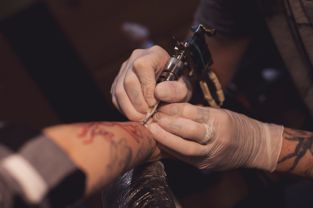Tattoer using tattoo machine - Photo, Image