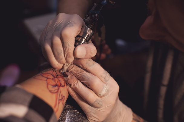 Татуировщик работает в салоне
 - Фото, изображение