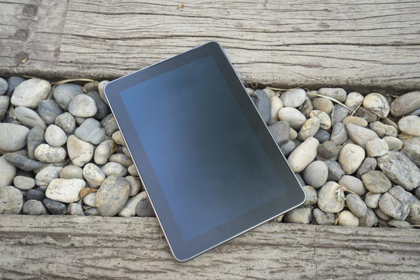 tableta digital en piedra y pasarela de madera
 - Foto, imagen