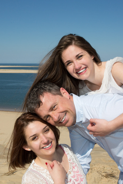 Ritratto di una famiglia felice a cavalcioni della figlia in spiaggia
 - Foto, immagini