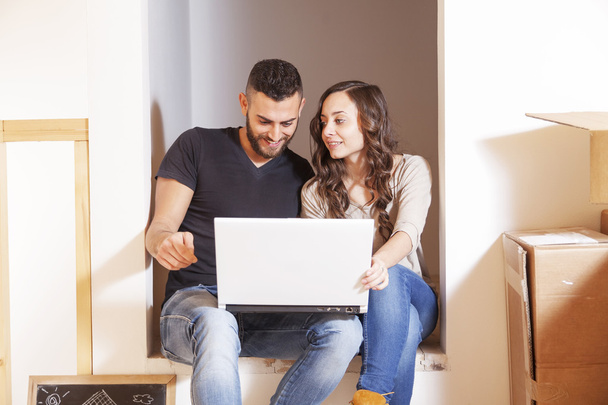 νεαρό ζευγάρι σχεδιάζει να υπολογιστή το μέλλον στο νέο σπίτι - Φωτογραφία, εικόνα