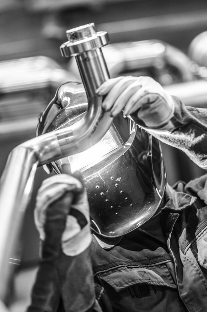 Industrial worker welding in metal factory. - Foto, Bild