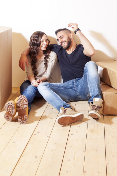 young couple relaxing after moving between the boxes - Photo, Image