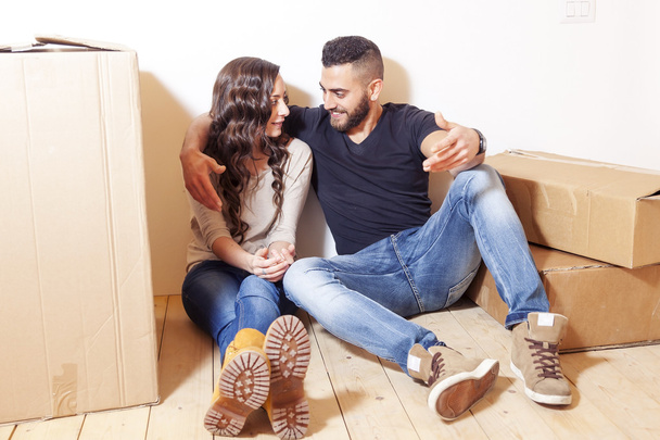 young couple relaxing after moving between the boxes - Photo, Image