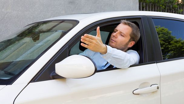 Geschäftsmann in seinem Auto macht eine Geste - Foto, Bild
