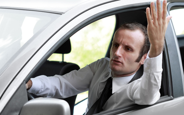 Бізнесмен у своїй машині робить жест
 - Фото, зображення