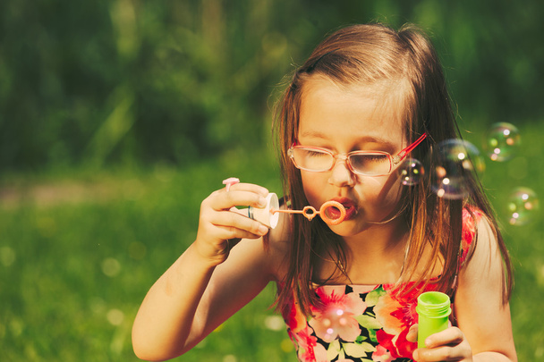 Little girl child blowing soap bubbles outdoor. - Fotografie, Obrázek