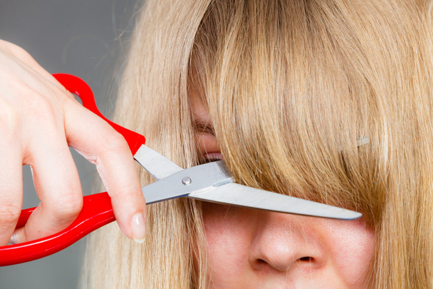 Woman cutting her fringe. - Foto, Imagen