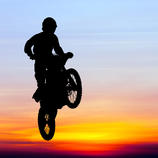 silueta de motocross rider saltar en el cielo al atardecer
 - Foto, Imagen