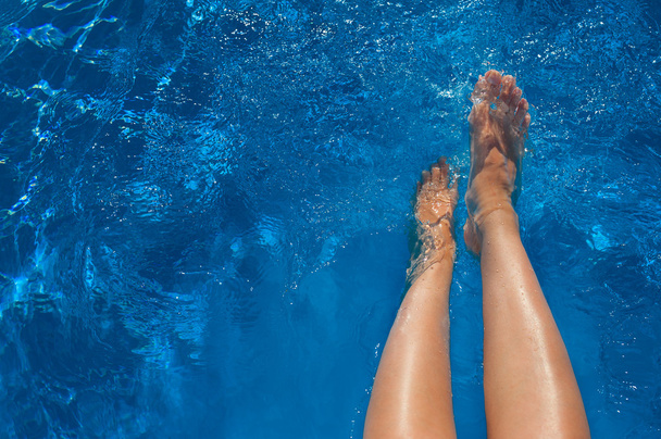 jambes de femme dans la piscine d'eau bleue
 - Photo, image