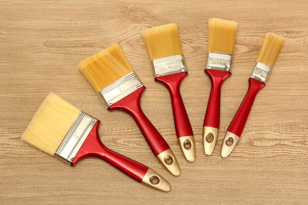Paint brushes on wooden background - 写真・画像