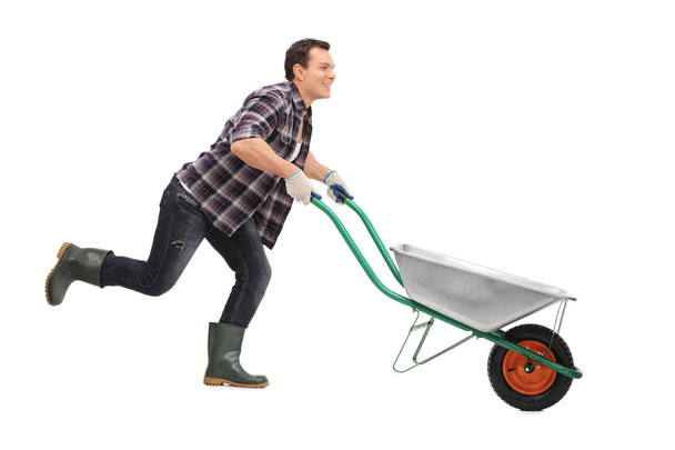Man pushing wheelbarrow and running  - Fotografie, Obrázek