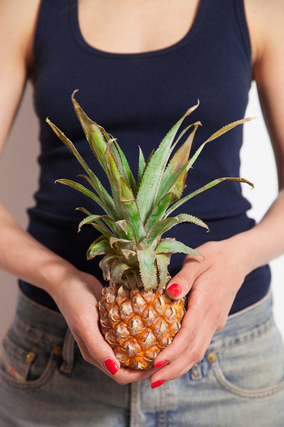 Young woman holding pineapple - Фото, изображение