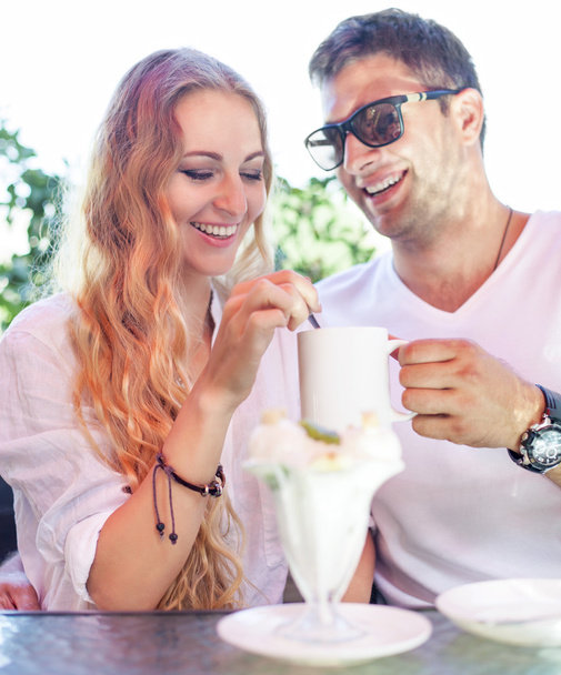 Fiatal pár élvezi a kávét egy utcai kávézóban  - Fotó, kép