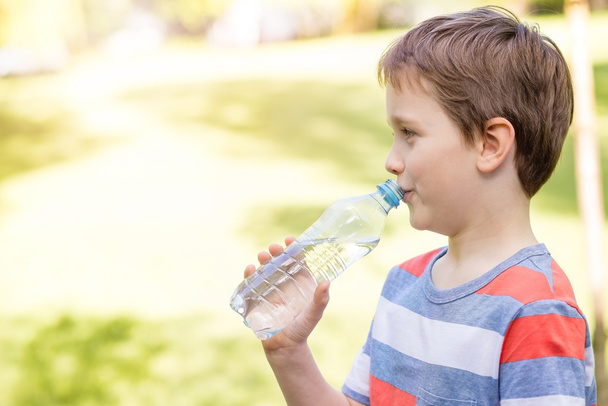 niño beber agua mineral de la botella de plástico
 - Foto, Imagen