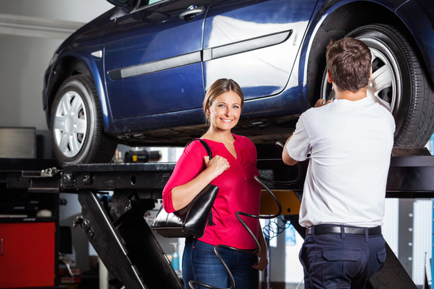 Customer Standing With Mechanic Refilling Tire - Foto, Imagen
