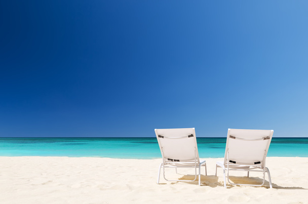 Cadeiras de praia com guarda-chuva e bela praia de areia
  - Foto, Imagem