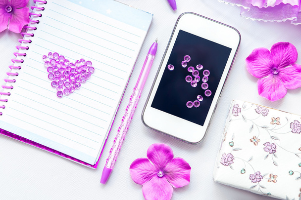 Office supplies business women. Phone, notebook and pen. Some office stuff on a white background. Accessories on the table. Purple pink color interior details. - Photo, Image