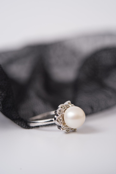 ένα μαργαριτάρι δαχτυλίδι στο ύφασμα δαντέλα - Φωτογραφία, εικόνα
