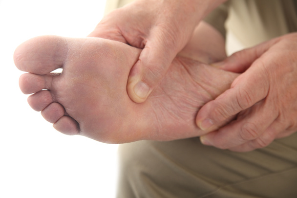 Homem verifica seu pé dolorido
 - Foto, Imagem