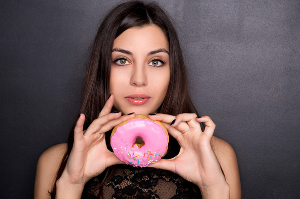 Beautiful girl holds a pink donut - Photo, Image