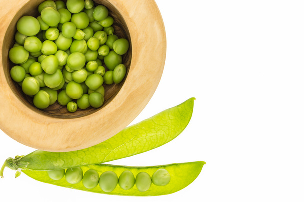 Fresh green peas in wooden bowl, on white background with copy-space - Photo, Image