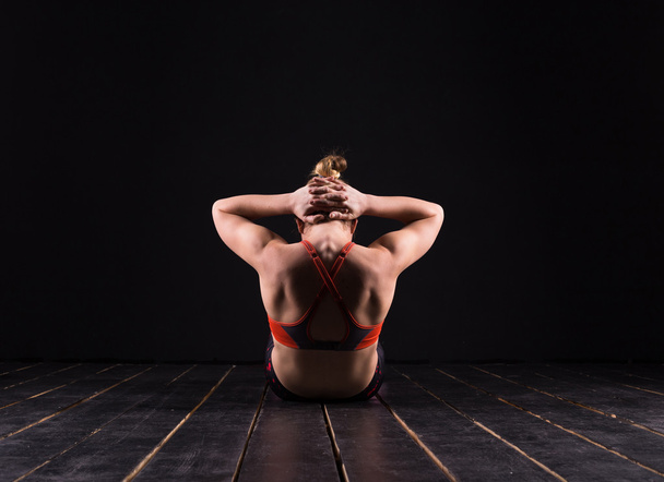 Beautiful young and fit fitness sport model doing yoga in dark studio - Zdjęcie, obraz