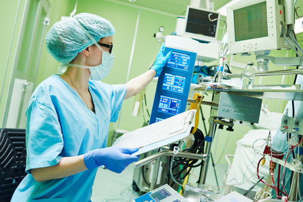 Surgery assistant perfusionist operating a modern heart lung machine - Фото, зображення