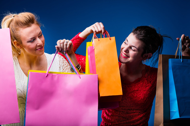 femmes faisant du shopping avec beaucoup de sacs sur bleu
 - Photo, image
