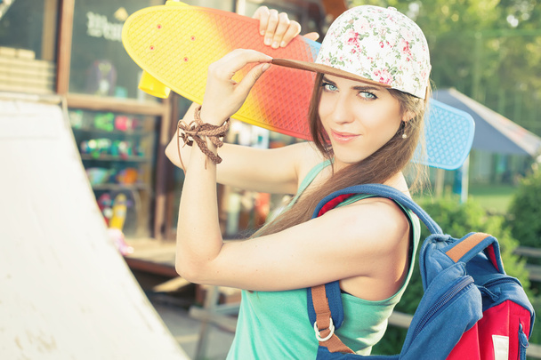 Fashion skateboarder young woman with a skateboard - Foto, Imagen