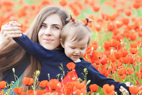 Mother with funny child outdoor at poppy flowers field - Φωτογραφία, εικόνα