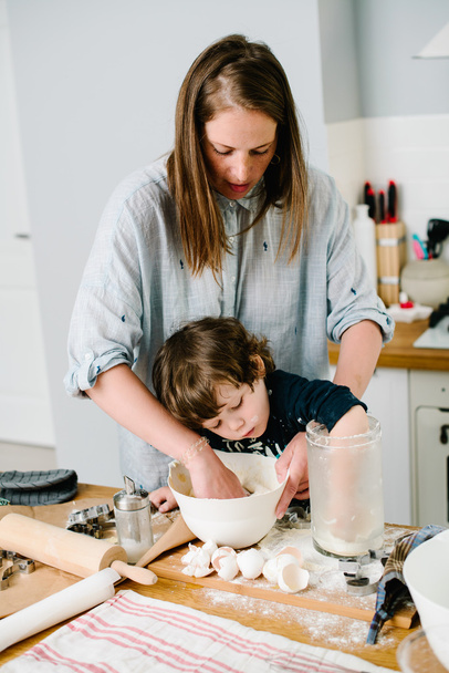 Pieni poika auttaa äitiään leivonnassa keittiössä sta
 - Valokuva, kuva
