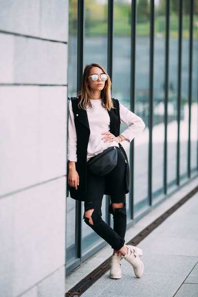 Street fashion concept - pretty young slim woman in rock black style posing against the  wall - Zdjęcie, obraz