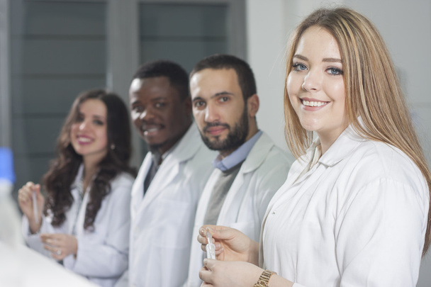 Ryhmä nuoria terveydenhuollon työntekijöitä työskentelee laboratoriossa laboratorioteknikkona
 - Valokuva, kuva