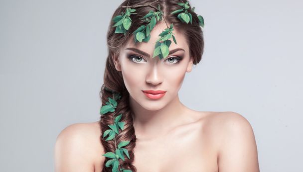 Beautiful Girl With fresh green leaves in her hair. Beauty Model - Фото, зображення