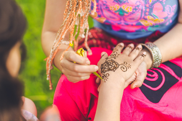 Foto de mano humana siendo decorada con tatuaje de henna, mehendi
 - Foto, Imagen