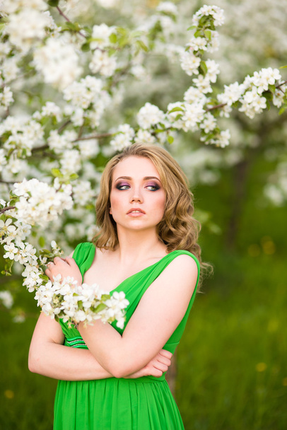 Beautiful happy young woman in spring blossoming garden - Valokuva, kuva