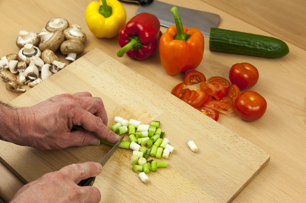 Primer plano de un chefs manos picando algunas cebollas para ensaladas
 - Foto, Imagen