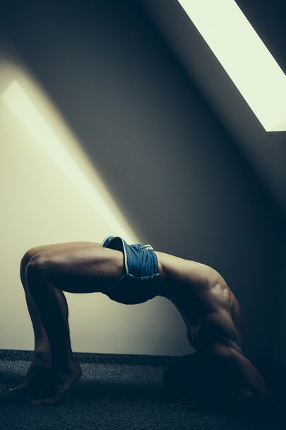 Muscular yoga man in bridge position - Foto, Bild