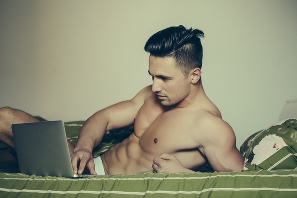Sexy man in bed with laptop - Zdjęcie, obraz