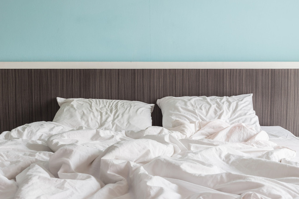 Sábanas blancas y almohada, concepto de cama desordenado
 - Foto, imagen