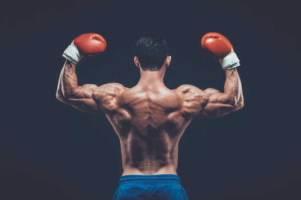 Muscular boxer in studio shooting, on black background. - Φωτογραφία, εικόνα