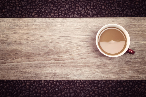 Taza de café y granos de café sobre fondo de madera, Enfoque en la taza
 - Foto, imagen