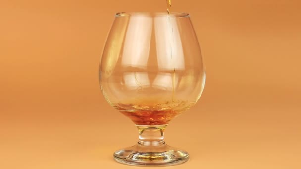 Gros plan de brandy étant versé dans snifter sur fond brun
 - Séquence, vidéo