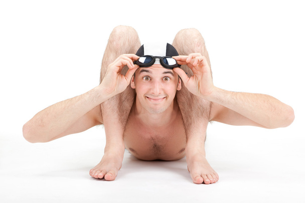 smiling happy flexible contorsionist swimmer with cap and goggles on grey background - Foto, Imagen