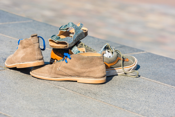 Chaussures de famille laissées sur un trottoir
 - Photo, image