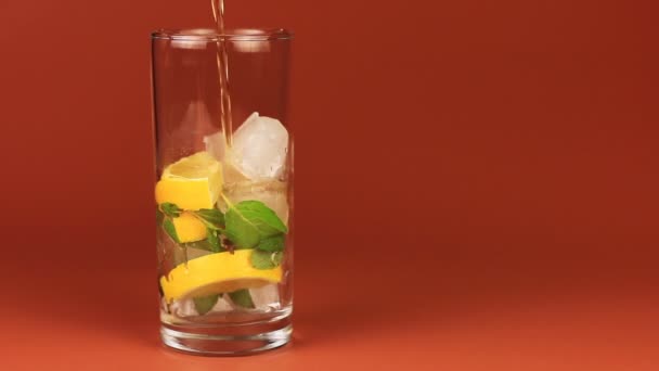 ミント、レモン、茶色の背景に氷と氷茶のガラス. - 映像、動画