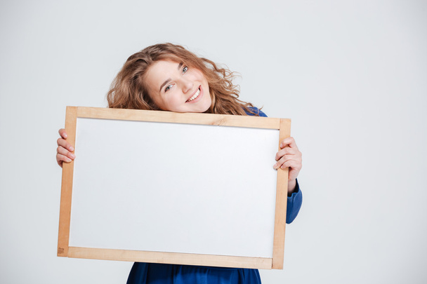 Mujer sonriente sosteniendo tablero en blanco
 - Foto, Imagen