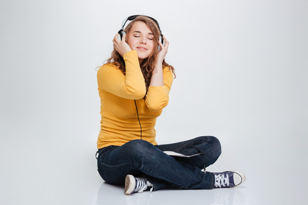 Femme heureuse écoutant de la musique dans les écouteurs
 - Photo, image